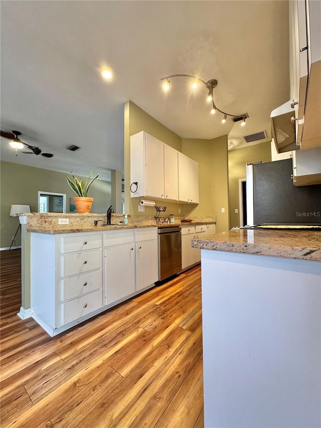 kitchen featuring white cabinets, light wood-type flooring, kitchen peninsula, stainless steel appliances, and light stone counters