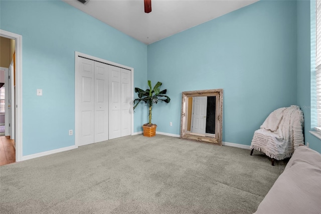 unfurnished bedroom featuring ceiling fan, light colored carpet, and a closet