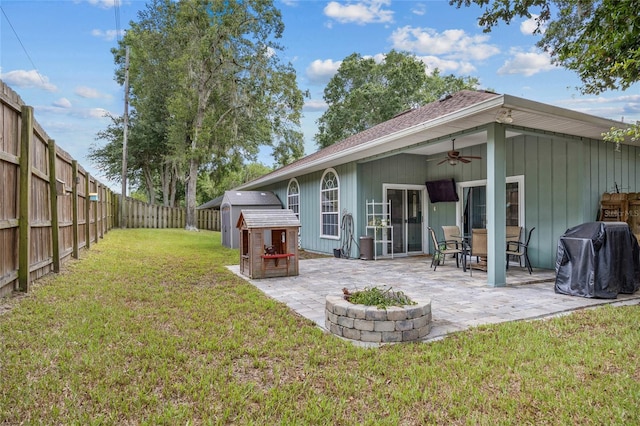 back of house with ceiling fan, a patio area, and a lawn