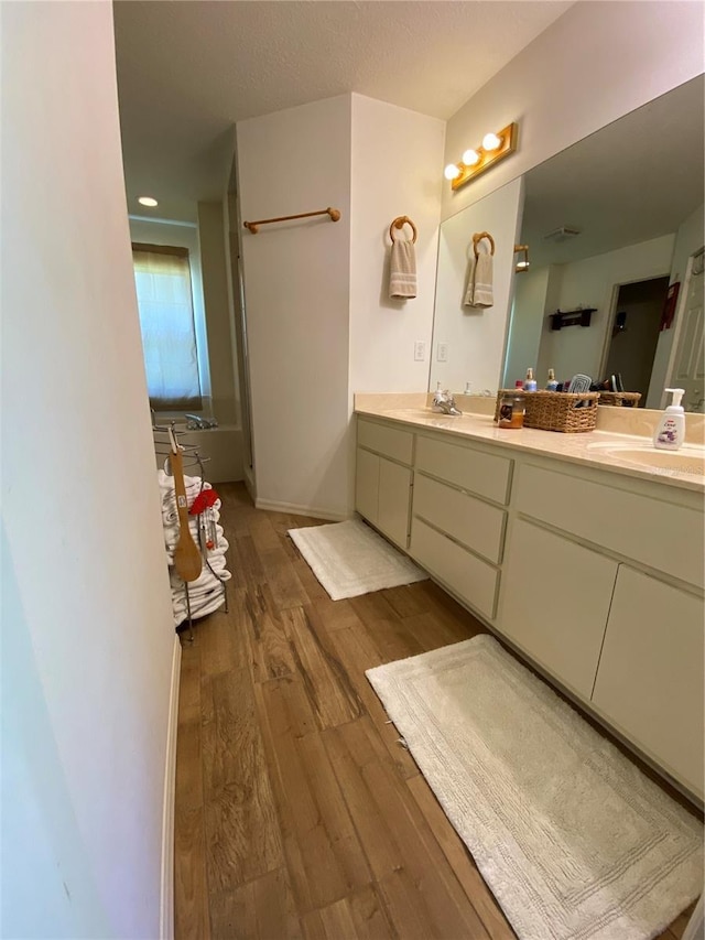 bathroom featuring vanity, wood-type flooring, and a textured ceiling