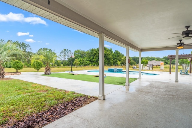 view of pool featuring a lawn, ceiling fan, a patio, and a hot tub