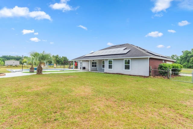 view of front facade featuring a front yard and solar panels