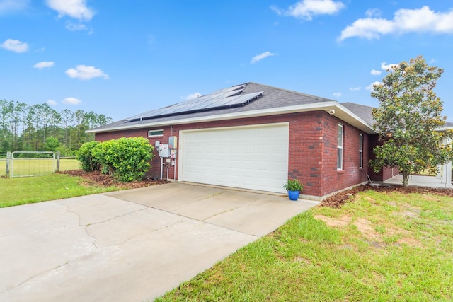 view of side of property with a lawn, a garage, and solar panels