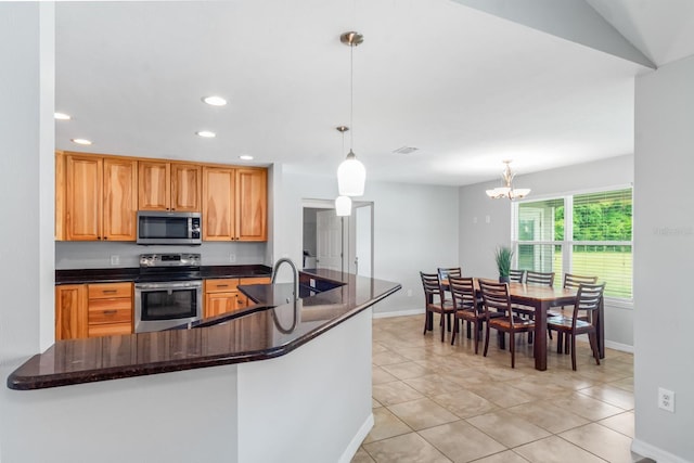 kitchen with kitchen peninsula, stainless steel appliances, an inviting chandelier, and hanging light fixtures