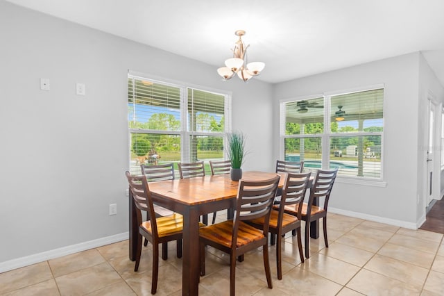 dining area featuring light tile patterned floors and ceiling fan with notable chandelier