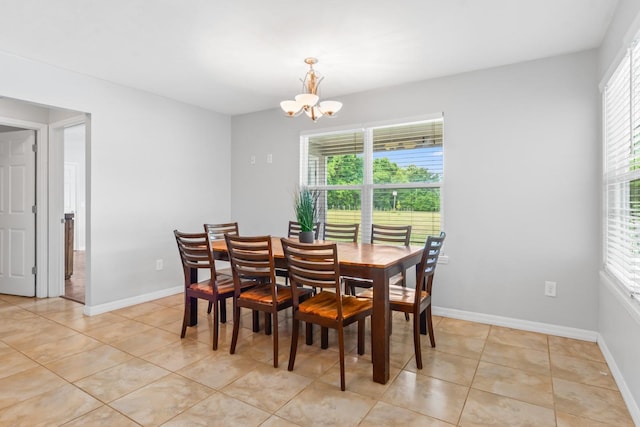 dining area featuring light tile patterned floors and an inviting chandelier