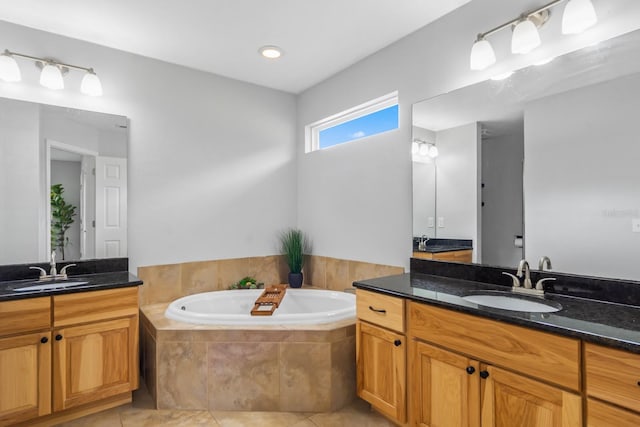 bathroom featuring tile patterned floors, tiled tub, and vanity