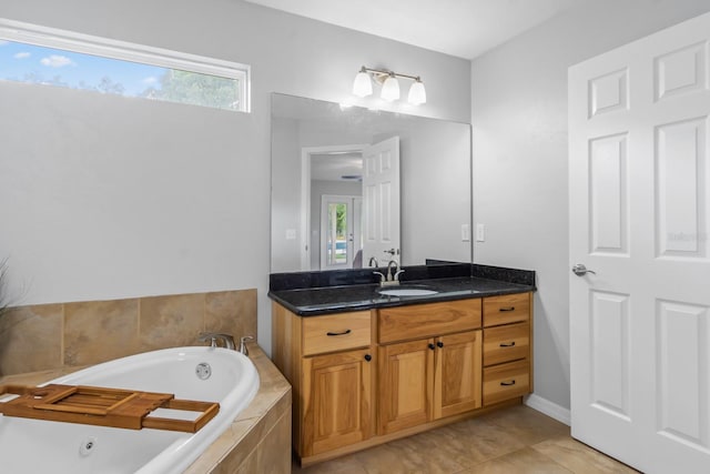 bathroom with tiled bath, plenty of natural light, vanity, and tile patterned flooring