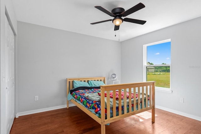 bedroom with ceiling fan, a closet, and dark hardwood / wood-style floors