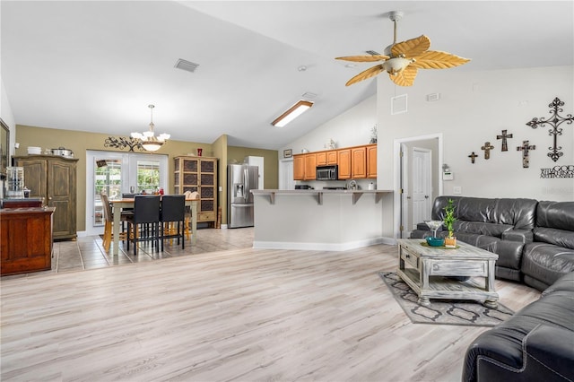 living area featuring ceiling fan with notable chandelier, visible vents, high vaulted ceiling, and light wood-style floors