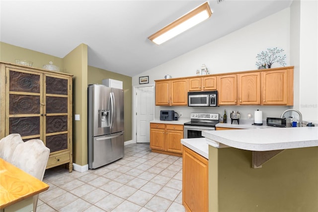 kitchen with sink, high vaulted ceiling, light tile patterned floors, appliances with stainless steel finishes, and kitchen peninsula