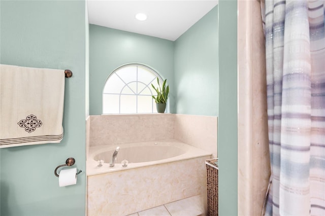 bathroom with a relaxing tiled tub and tile patterned flooring