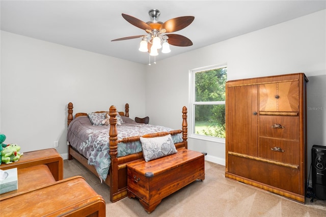 bedroom featuring baseboards, a ceiling fan, and light colored carpet