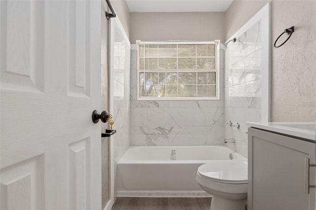 full bathroom with tiled shower / bath, vanity, toilet, and hardwood / wood-style floors