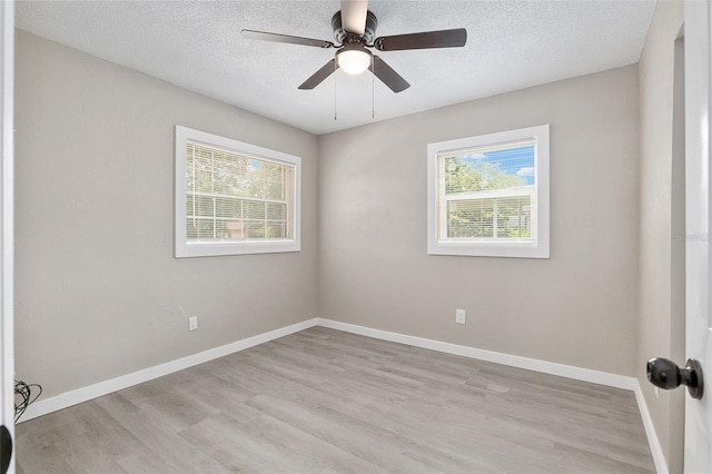 spare room featuring ceiling fan, light hardwood / wood-style floors, and a textured ceiling