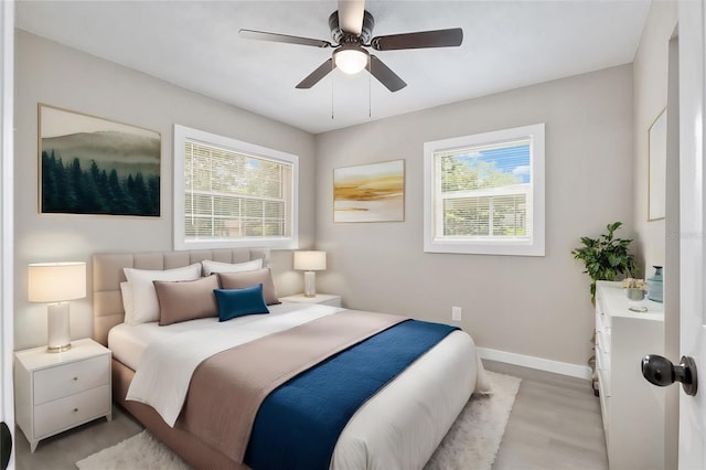 bedroom with multiple windows, light wood-type flooring, and ceiling fan