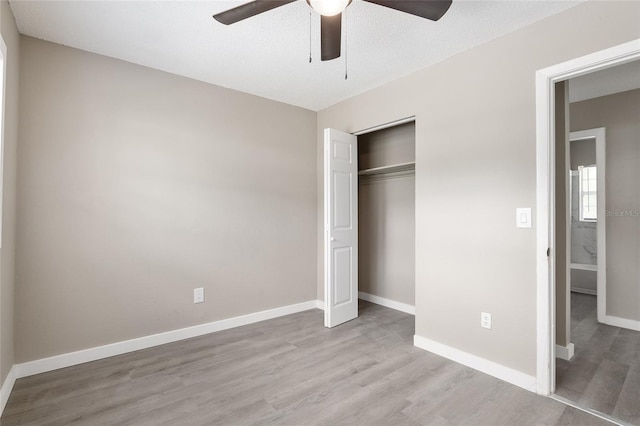 unfurnished bedroom with ceiling fan, a textured ceiling, light hardwood / wood-style floors, and a closet