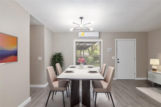 dining space with an AC wall unit, a chandelier, and light hardwood / wood-style flooring