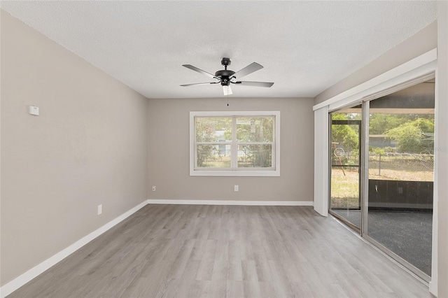 empty room featuring ceiling fan, light hardwood / wood-style floors, and a textured ceiling