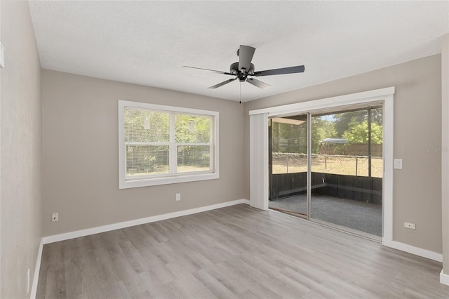 unfurnished room featuring ceiling fan, light hardwood / wood-style floors, and a textured ceiling