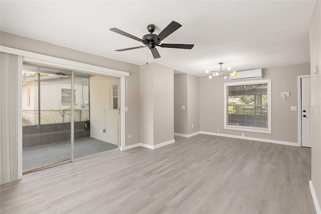 unfurnished living room with a wealth of natural light, light hardwood / wood-style floors, and an AC wall unit