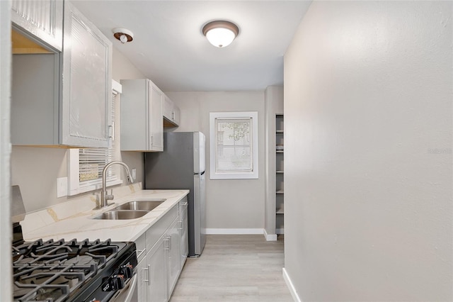 kitchen featuring sink, stainless steel appliances, light hardwood / wood-style floors, and white cabinets