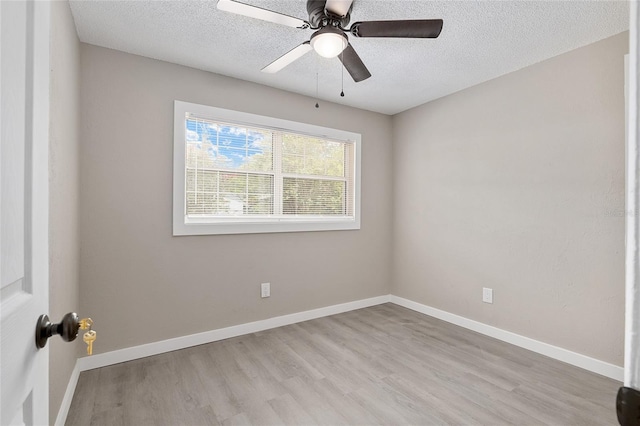 empty room with ceiling fan, a textured ceiling, and light wood-type flooring