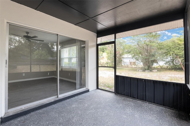 unfurnished sunroom featuring ceiling fan