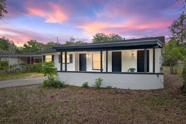 919 SE 19th St, Gainesville, FL 32641 - view of front of home featuring stucco siding, fence, and covered porch