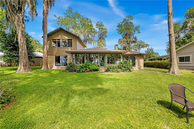 rear view of property featuring a lawn