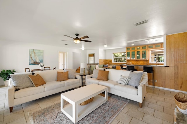 living room featuring ceiling fan, light tile floors, and rail lighting