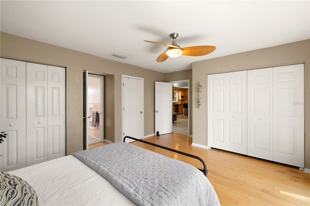 bedroom featuring multiple closets, ceiling fan, and light hardwood / wood-style flooring