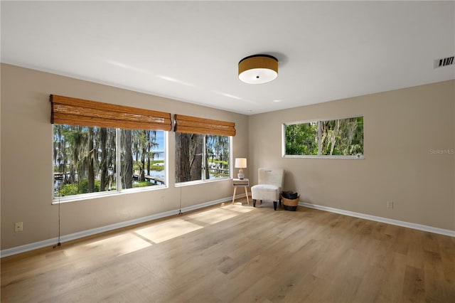 unfurnished room with a wealth of natural light and light hardwood / wood-style flooring