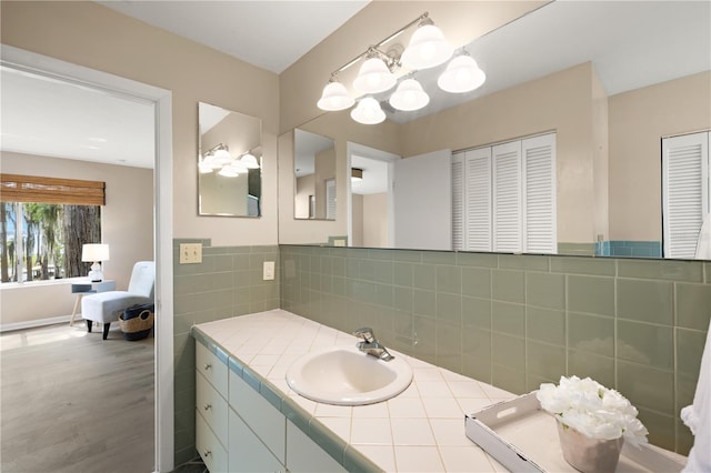 bathroom featuring backsplash, vanity, hardwood / wood-style floors, and a notable chandelier