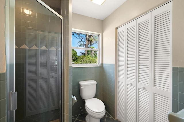 bathroom featuring tile walls, tile flooring, and toilet