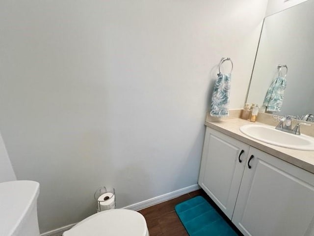 bathroom with hardwood / wood-style flooring, vanity, and toilet