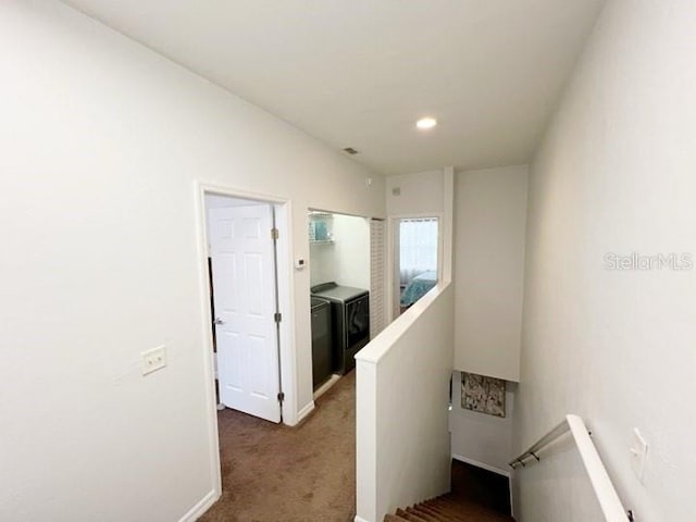 corridor with dark colored carpet and washing machine and dryer