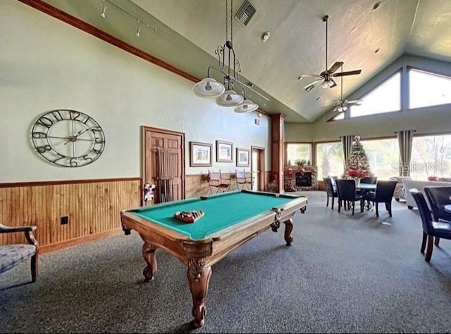 game room featuring a towering ceiling, wood walls, carpet, pool table, and ceiling fan