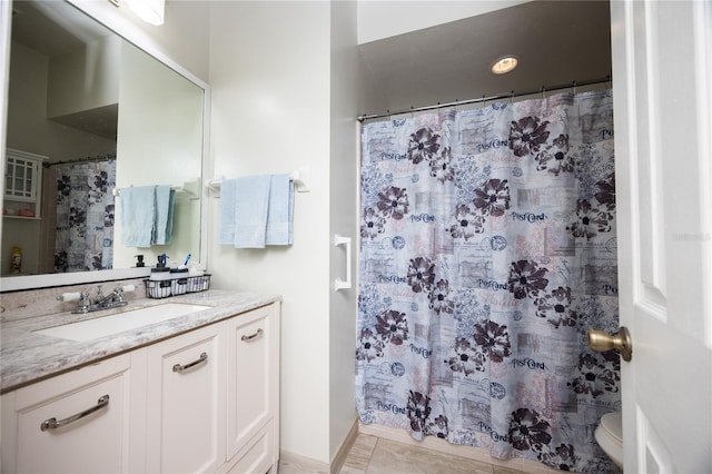 bathroom with tile patterned floors, walk in shower, vanity, and toilet