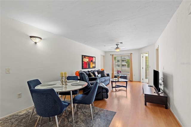 dining space with hardwood / wood-style flooring and ceiling fan