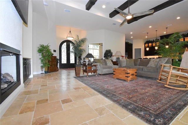 living room with french doors, ceiling fan, and a high ceiling