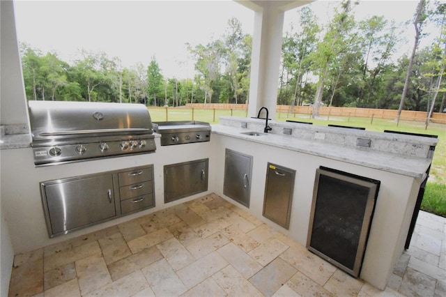 view of patio / terrace with an outdoor kitchen, grilling area, and sink