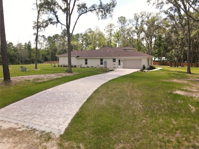 rear view of property with a garage and a lawn