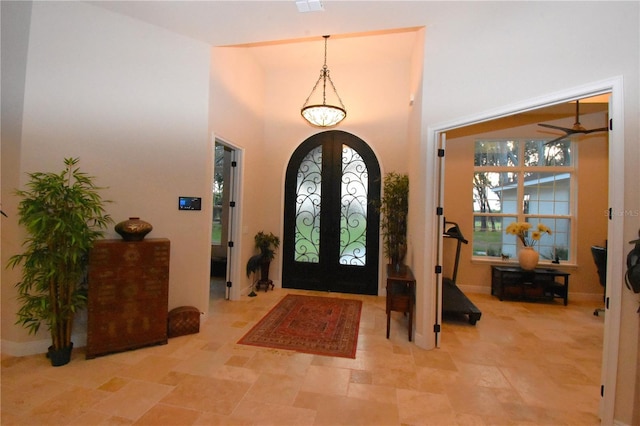 foyer entrance featuring french doors, plenty of natural light, and a high ceiling