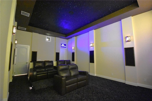 home theater room featuring carpet flooring and a tray ceiling