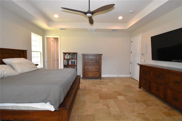 bedroom with ceiling fan and a raised ceiling