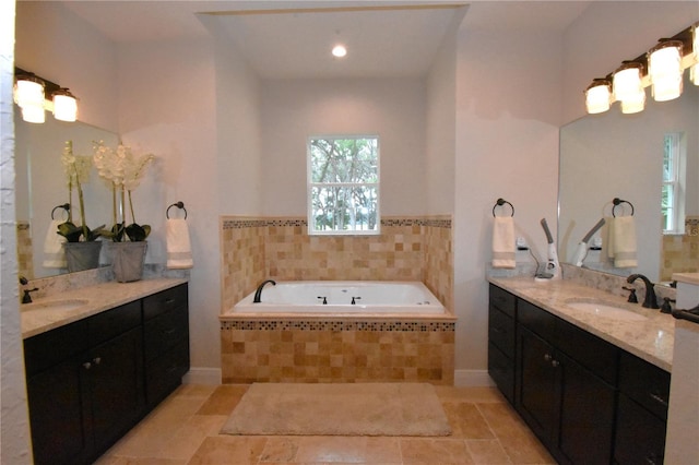 bathroom featuring vanity and tiled bath