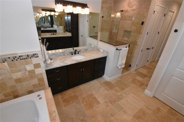 bathroom with vanity, a bath, and tile walls