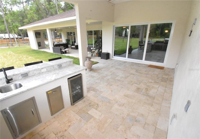 view of patio featuring area for grilling, sink, and outdoor lounge area