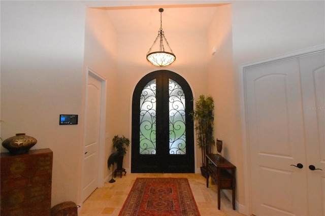 entryway featuring a towering ceiling and french doors